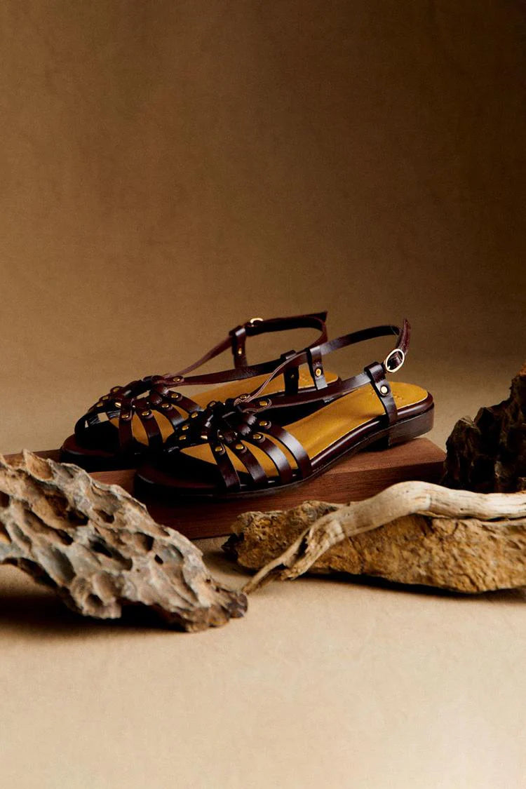 Sandali con borchie metalliche e intagli in marrone scuro